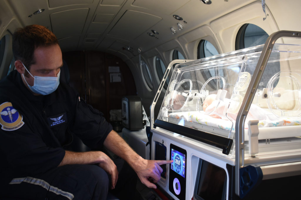 Airborne nurse configuring incubator settings mid-flight