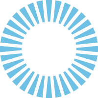 A circular graphic composed of alternating segments in light blue, radiating outwards from a central empty space, creating a sunburst effect. The design gives a sense of motion and energy, with the segments resembling rays or spikes extending outward.