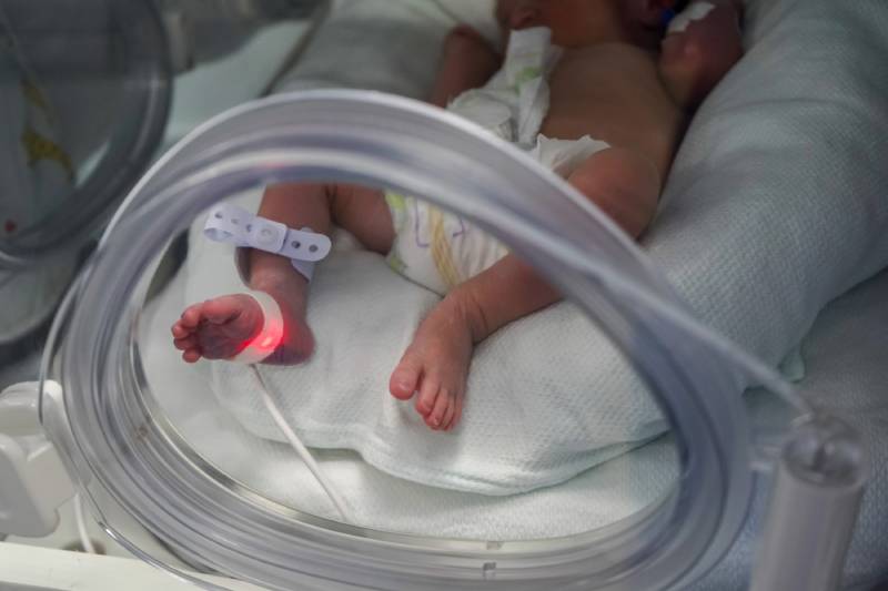 Newborn baby in a NICU incubator.