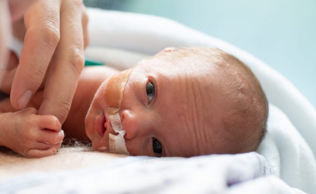 Father taking care of his premature baby  doing skin to skin at hospital. Color and horizontal photo was taken in Quebec Canada.